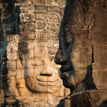 Stone faces carved into the towers of Bayon temple, an activity at Amansara in Cambodia.