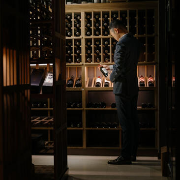 Sommelier examining wines in the temperature-controlled cellar at Amanyangyun, China.