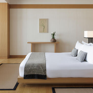 Principal bedroom with king bed, wooden desk and tatami flooring at Aman Tokyo.