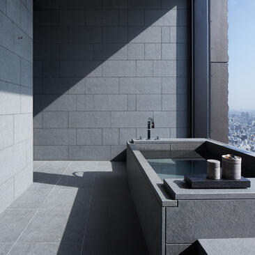 Onsen bathtub in an Aman Suite at Aman Tokyo, with views across the city.