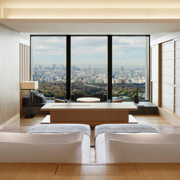 Twin-bedroom suite at Aman Tokyo with city views from expansive windows.