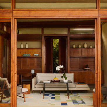 Sala de estar en Amanera resort con muebles de madera clara y almacenamiento integrado.