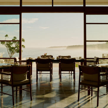 Amanera's main dining room with wooden tables and chairs overlooking Dominican landscape.