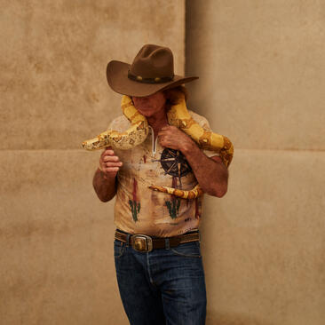 A child wearing a cowboy hat and patterned western shirt at Amangiri's wildlife workshop.