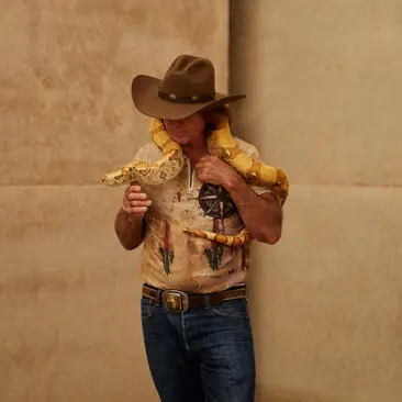 A child wearing a cowboy hat and golden-yellow shirt at Amangiri resort's wildlife workshop.