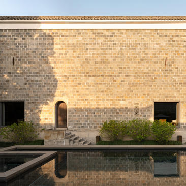Four-bedroom villa exterior at Amanyangyun with reflecting pool and traditional brick façade.