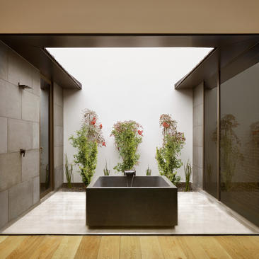 Outdoor jacuzzi at Amanyangyun surrounded by potted plants and stone walls, China.