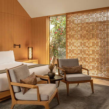 Ming Pavilion seating area at Amanyangyun with wooden walls, lattice screens and mid-century furniture.
