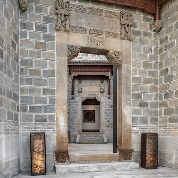 Exterior entrance to a four-bedroom villa at Amanyangyun, featuring traditional stone archway and wooden doors.