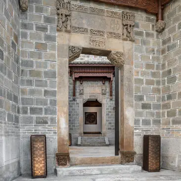 Exterior entrance to a four-bedroom villa at Amanyangyun, featuring traditional stone archway and wooden doors.