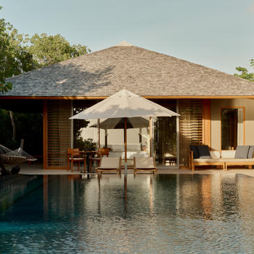Amanyara pavilion with thatched roof overlooking an infinity pool, Turks and Caicos.