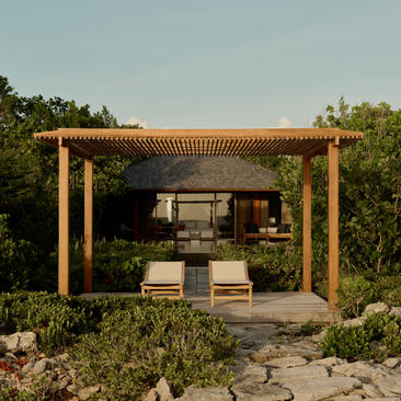 Wooden pavilion with seating area at Amanyara, surrounded by tropical vegetation.