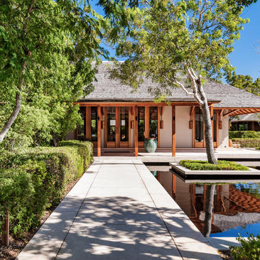 Four-bedroom beach villa at Amanyara with wooden pavilion and tranquil pathway through tropical gardens.