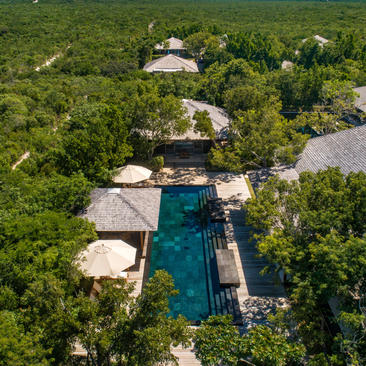 Aerial view of four-bedroom beach villa at Amanyara surrounded by lush tropical vegetation and ocean access.