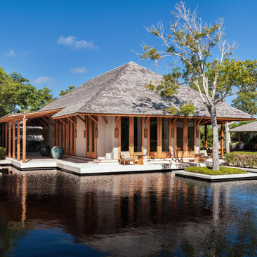 Four-bedroom beach villa at Amanyara with thatched roof overlooking tranquil lagoon, Turks and Caicos.