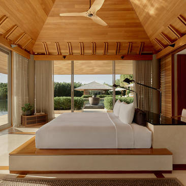 Four-bedroom villa principal bedroom with wooden interior and ocean view at Amanyara, Turks and Caicos.