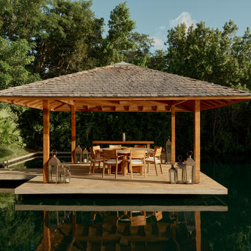 Four-bedroom villa's open-sided pavilion with dining area overlooking still waters at Amanyara, Turks and Caicos.