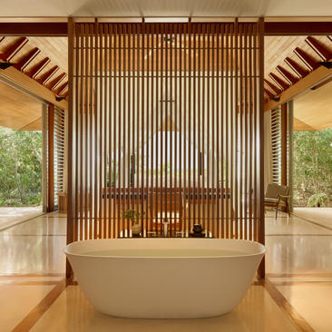 Ocean Cove Pavilion bathtub at Amanyara with wooden slat feature wall and open views to Turks and Caicos landscape.
