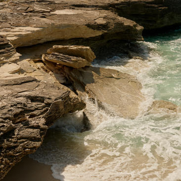 Ocean cove pavilion with weathered rock formations and turquoise waters at Amanyara, Turks and Caicos.