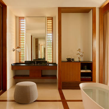 Amanyara Ocean Pavilion bathroom with wooden vanity, mirror and soaking tub.