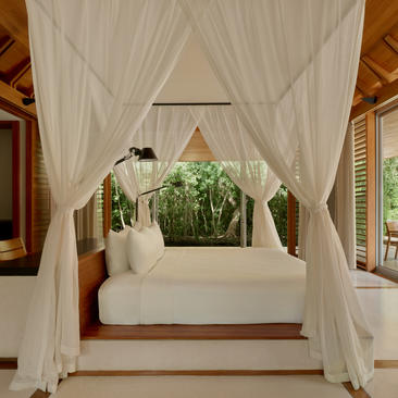 Pool pavilion with draped white curtains and central daybed at Amanyara, Turks and Caicos.