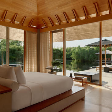 Three-bedroom villa at Amanyara with wooden ceiling, principal bedroom overlooking tropical gardens and pool terrace.