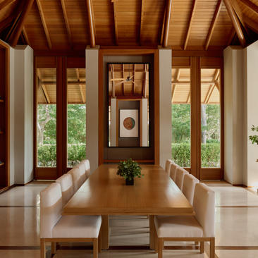 Three-bedroom Tranquility Villa dining pavilion at Amanyara with wooden ceiling and garden views through glass doors.