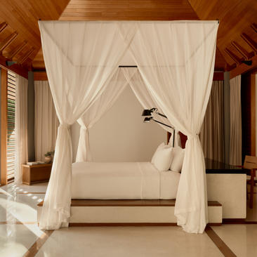 Two-bedroom pool villa at Amanyara with four-poster bed draped in white curtains, Turks and Caicos.
