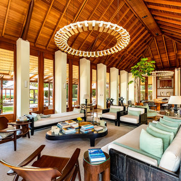 Spacious principal bedroom at Amanyara with soaring wooden ceiling, central circular skylight, and minimalist furnishings.