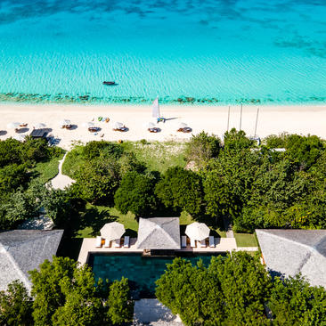 Aerial view of Bedroom 8 at Amanyara, surrounded by turquoise waters and tropical vegetation.