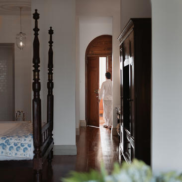 Amangalla chamber with four-poster bed and arched doorway leading to adjoining rooms.