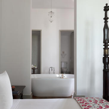 Principal bedroom bathroom at Amangalla with freestanding bath and decorative tile floor.