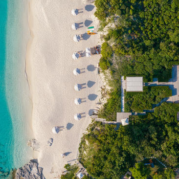 Aerial view of a four-bedroom beach villa at Amanyara with turquoise waters, white sand, and tropical vegetation.