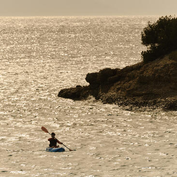 アマンゾイ・ビーチクラブで、海上のカヤックを楽しむ人物。