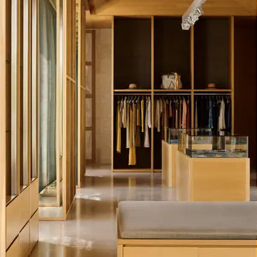 安缦卓熠度假村的精品店，展示衣架上的服装和米色展示柜。