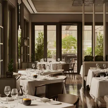 Restaurante Arva no Aman New York, com mesas elegantes e janelas que abrem para a cidade.