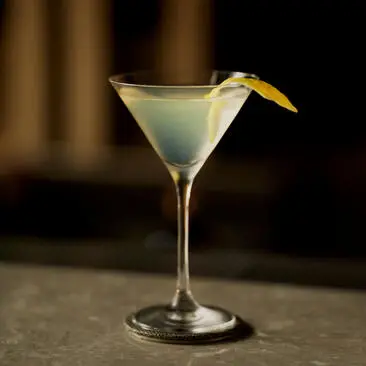 Coquetel servido no bar do hotel Aman New York, em taça martini com guarnição de limão.