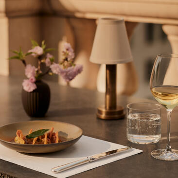 アマン ニューヨークのパスタ作り体験で、テーブルに盛られたパスタ料理、花、水のグラス。