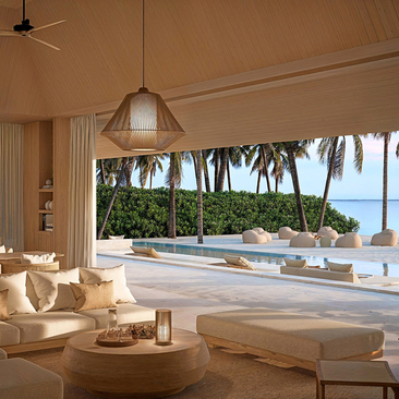 Beach pavilion at Amanzoe with open sides, neutral furnishings, and sea views beyond.
