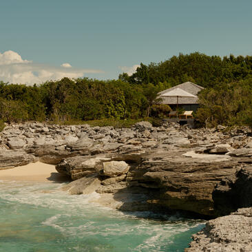 Ocean Cove Pavilion at Amanyara, perched on rocky coastline overlooking turquoise waters.