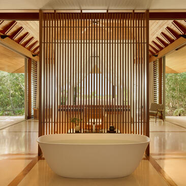アマンヤラのオーシャンコーブパビリオンの浴室。木製のスクリーンに囲まれた白い浴槽と広々とした空間。
