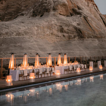 Terrasse piscine illuminée au crépuscule à Amangiri, resort désertique avec bougies et falaises ocre.