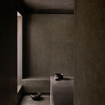 Amanoi forest wellness pool villa hammam interior with dark stone walls and minimalist design.