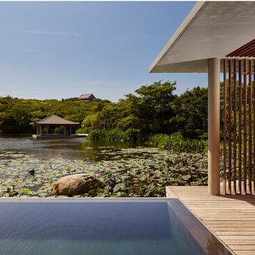 Amanoi lake wellness pool villa with plunge pool overlooking tranquil gardens and distant pavilion.