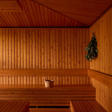 Wooden sauna interior at Amanoi with bench seating and hanging eucalyptus bundle.