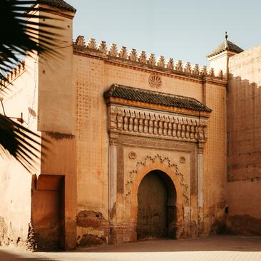 Ornate terracotta gateway with carved Islamic archway at Amanjena resort, Marrakech.
