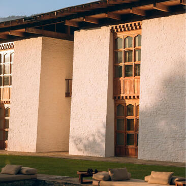 Amankora accommodation building in Bumthang with whitewashed walls and wooden window shutters.