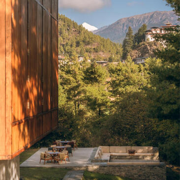 Wooden terrace at Amankora overlooking forested valley and mountains in Paro, Bhutan.