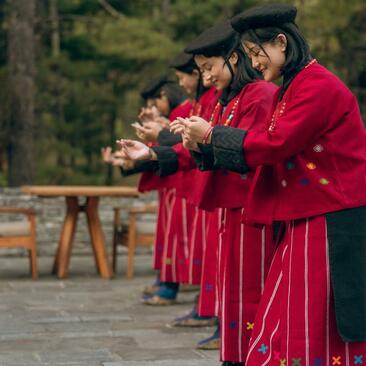Buddhist monks in crimson robes standing in a line at Amankora, Thimphu, Bhutan.