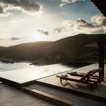 One-bedroom ocean pool residence at Amanoi with pool, ocean and mountain views at dusk.